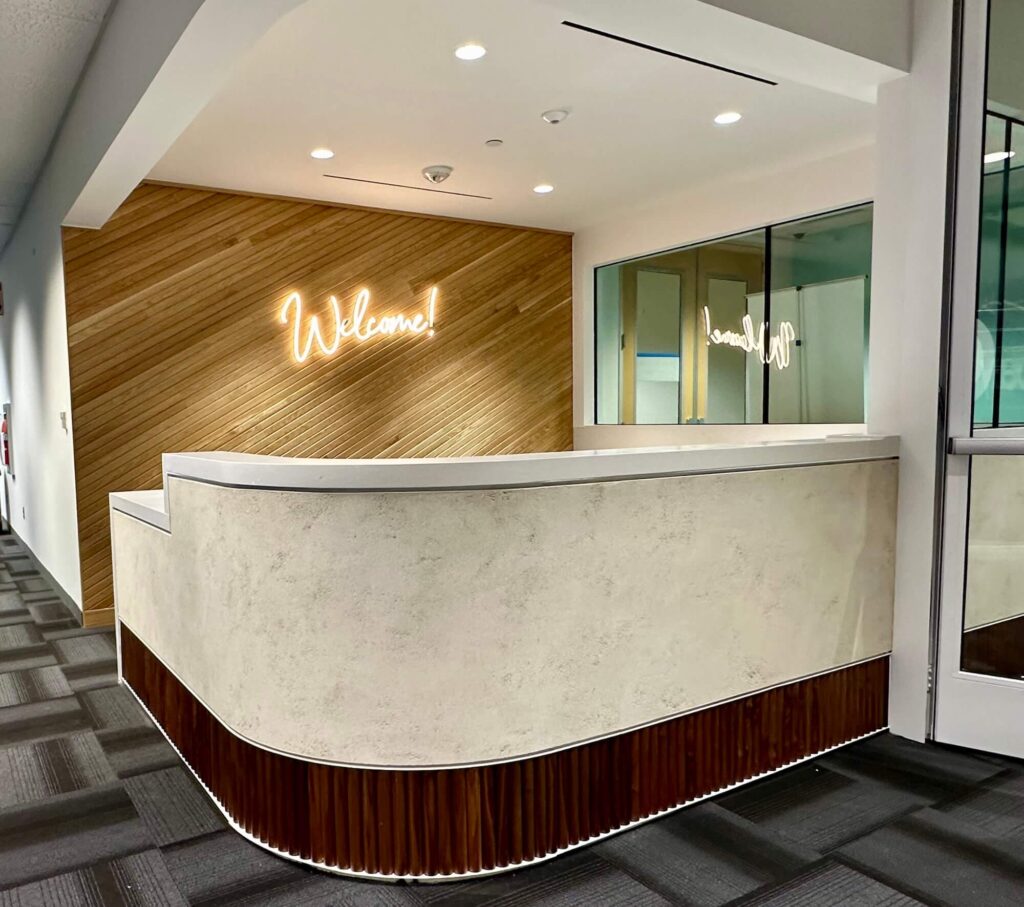 Artisan Clayworks plaster finish on a custom reception desk inside a luxury creative tech office in Central Texas.