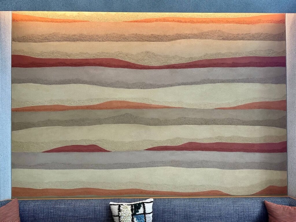 Custom hand troweled clay plaster in southwest desert colors inside a commercial high-rise lobby in downtown Austin.